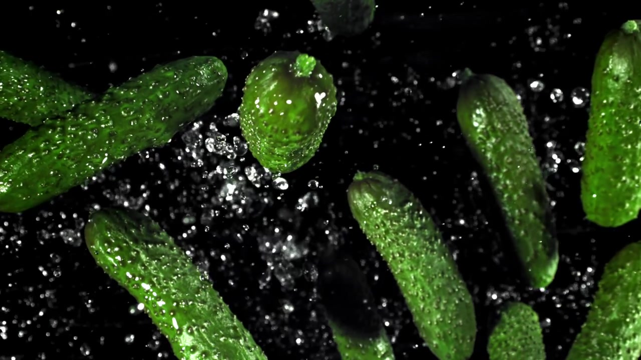 Cetrioli Verdi Freschi che Cadono e Schizzano con Goccioline d'Acqua su Sfondo Nero