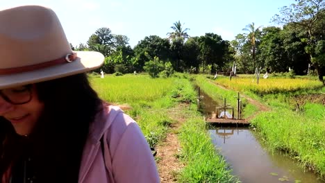 tourist woman walks with a camera in a cultivated area next to an irrigation canal in mto wa mbu