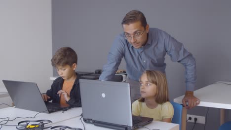 computer science teacher checking task of pupil girl