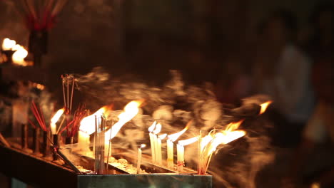 Prayer candles burn at a Burmese temple