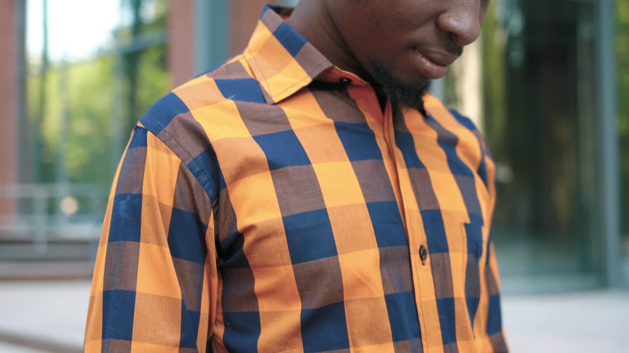 Close-up view of African american man using a smartphone during the break near the college