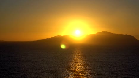 rising sun over the sea and desert mountains