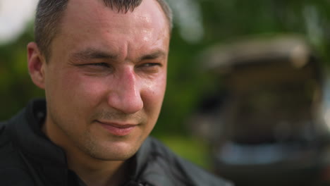 gentleman in jacket closes eyes partly on blurred background