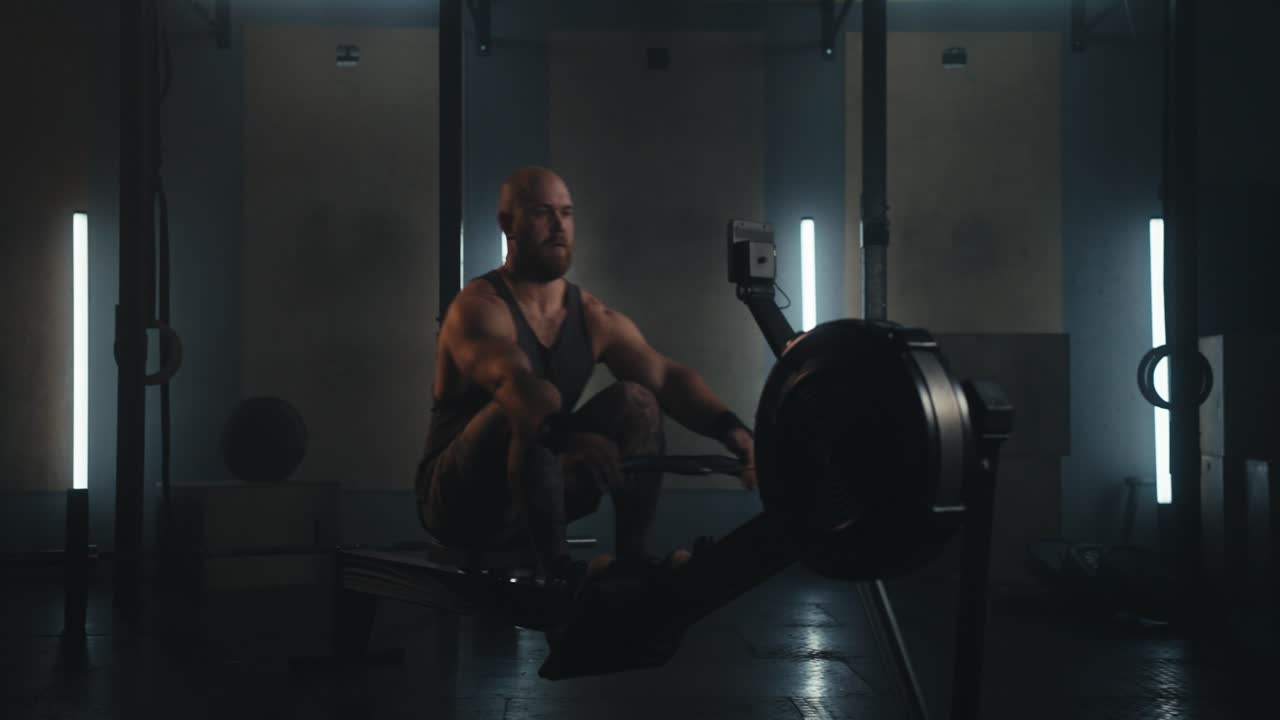 Uomo che si allena su un vogatore in palestra