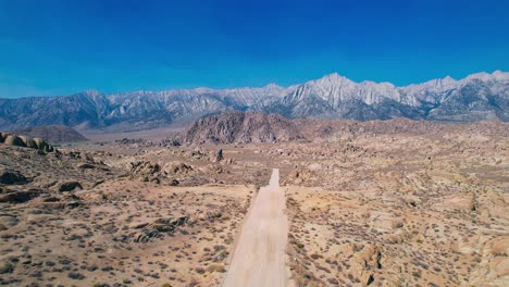 Alabama-Hills-En-Lone-Pine-California-Imágenes-De-Drones-De-4k-Tiran-Rápidamente-Hacia-Atrás-Sobre-La-Carretera-De-La-Película-Con-El-Monte-Whitney-En-El-Fondo