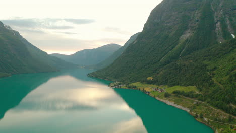 maisons sur la rive de la rivière avec les montagnes vertes à nordfjord à stryn, comté de vestland, norvège