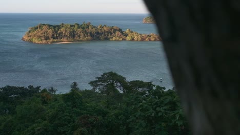 reveal shot of small tropical island with morning sunrise light hitting the island