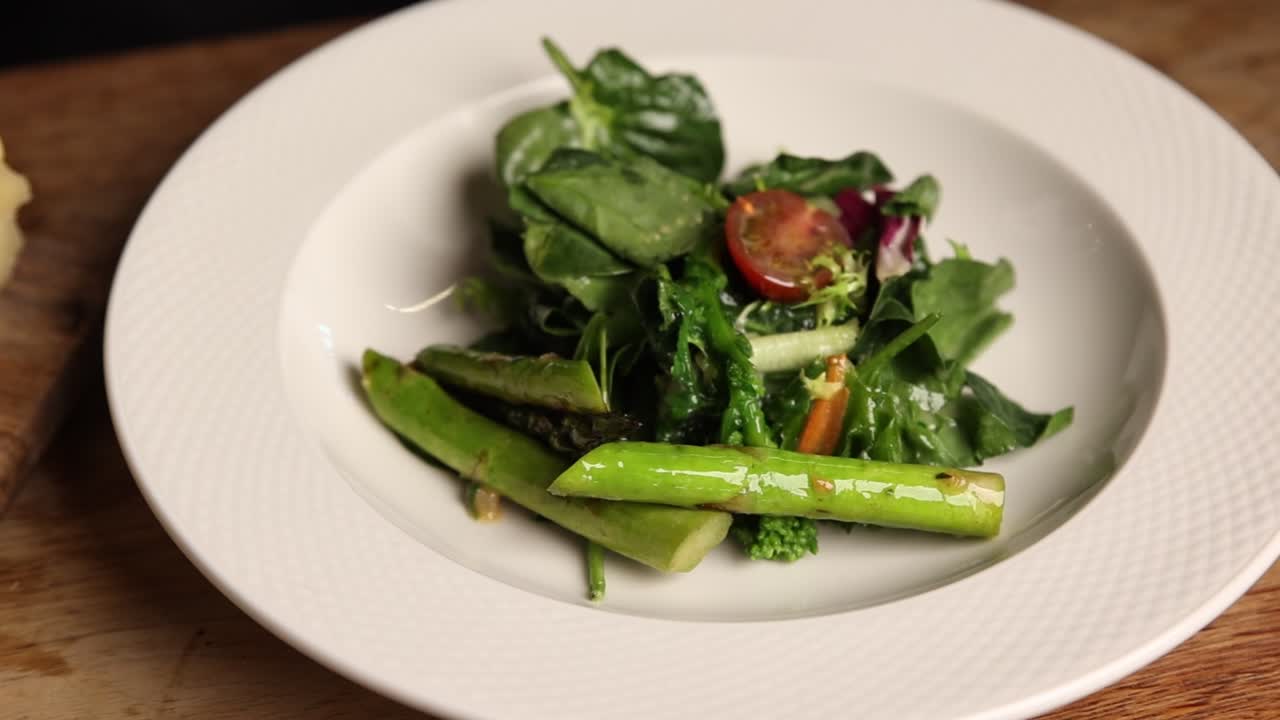 Frischen grünen Spargelsalat auf weißem Teller servieren