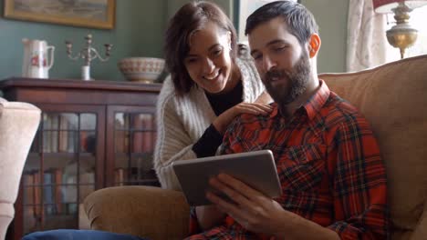 pareja usando una tableta digital en la sala de estar