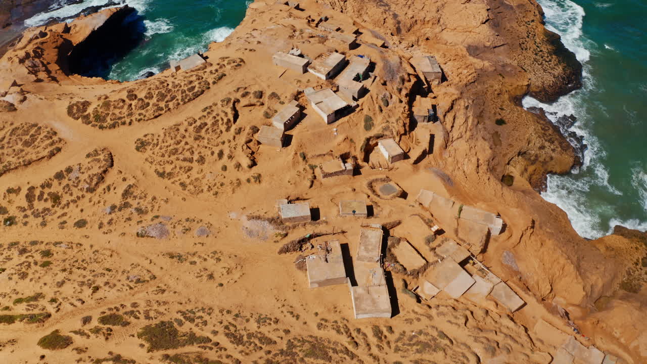 Aerial drone shot over the Tamri coastal sand dunes in Morocco.
High view of local remote village located on the coastline.