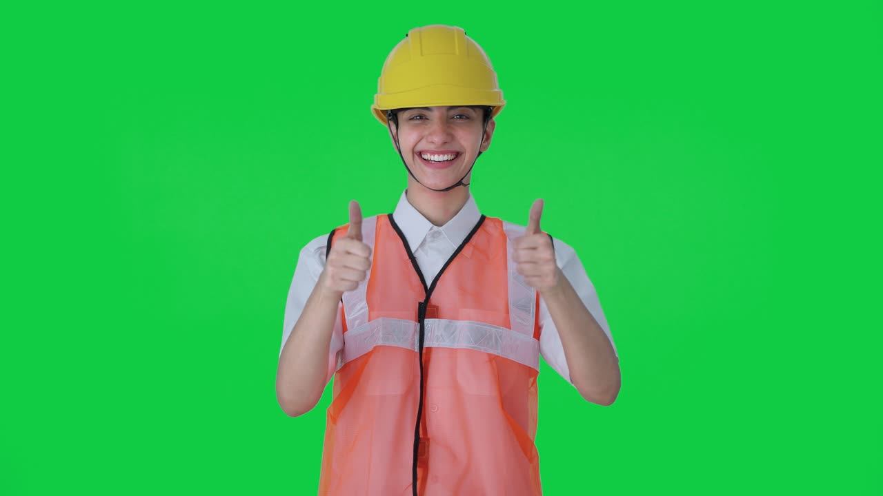 행복한 인도 여성 건축가가 엄지 손가락을 녹색 화면으로 올리고 있습니다.