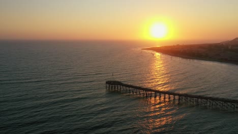 Deslumbrante-Puesta-De-Sol-Sobre-El-Océano-Pacífico-Con-Un-Muelle-De-Madera-En-La-Costa-De-California,-Ee.uu.