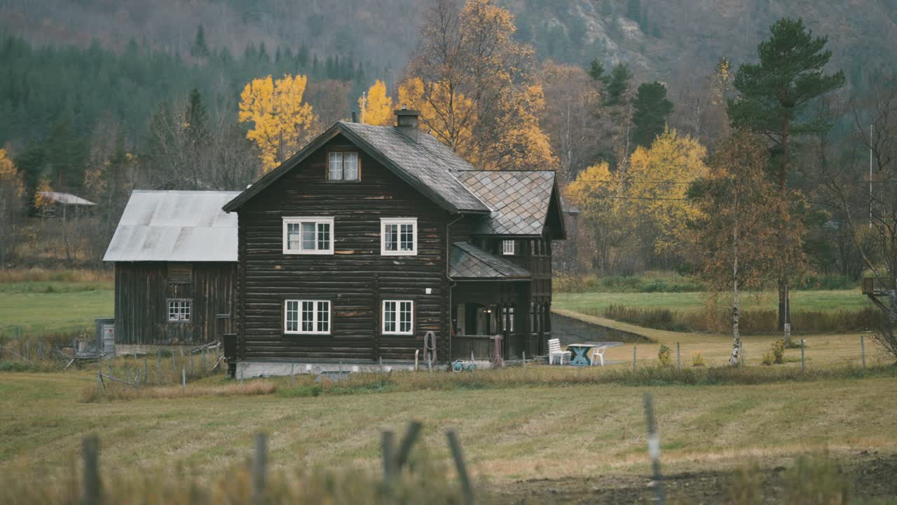 una antigua granja de madera en el paisaje otoñal