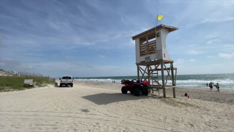 vehículo de rescate blanco con pocas personas en la playa de wrightsville en carolina del norte en un día soleado durante la marea alta