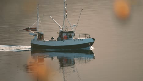 a small fishing ship crossing the fjord