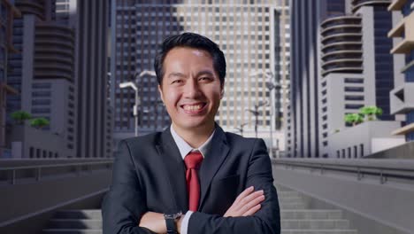 an asian business man crossed arms and warmly smiling in city