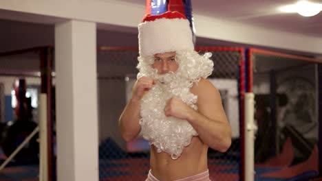 santa claus beats boxing bag angry santa claus santa claus kickboxer training in the gym the concept of sport