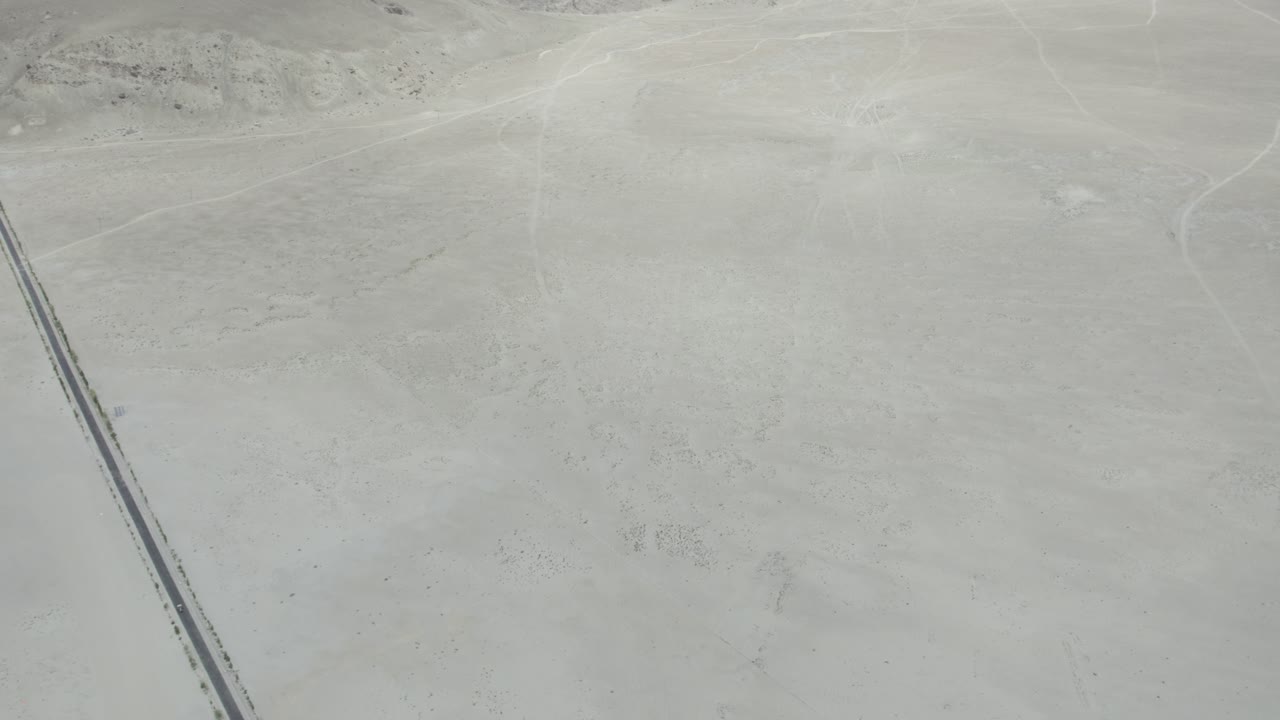 A straight road running across the pale sandy expanse of Skardu’s Cold Desert. Gilgit-Baltistan, Pakistan