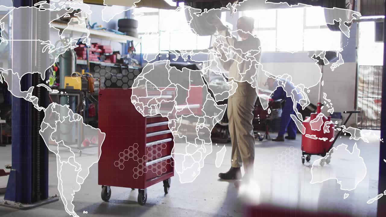 Two female mechanics working under car in garage, editing fading world-map overlay covering frame