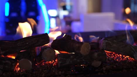 rollo de la cámara a la derecha lentamente de las llamas de fuego en una chimenea moderna, interior por la noche, cerca de 4k