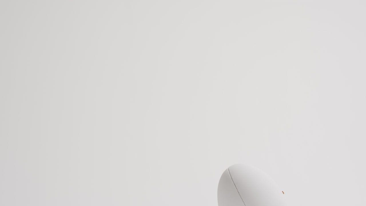pelota de rugby blanca en patear tee en fondo blanco con espacio de copia, cámara lenta