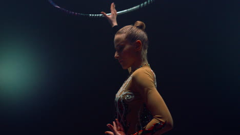 flexible woman posing camera during performance hula hoop. sportswoman training.