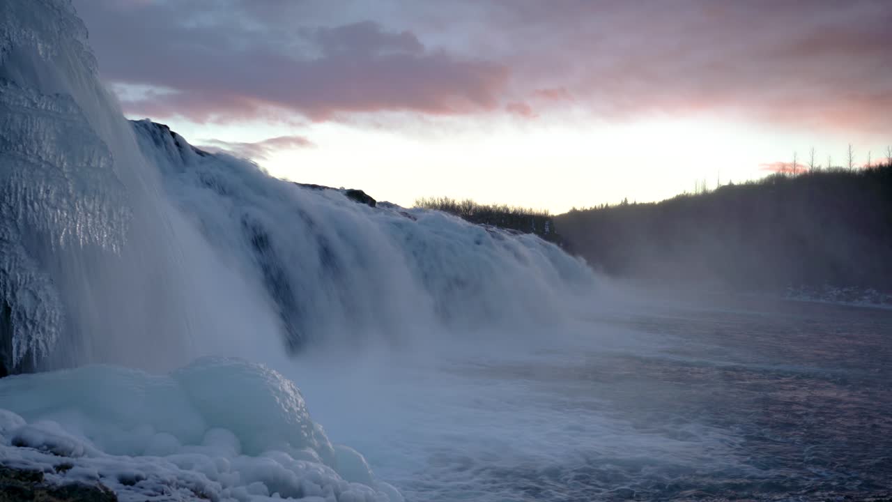 해질녘의 팩스 폭포 - 아이슬란드의 겨울에 강에서 튀는 폭포에서 흐르는 물