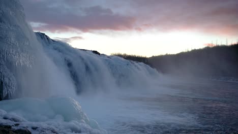 cascada de faxi al atardecer - agua que fluye de la cascada que salpica en el río en invierno en islandia