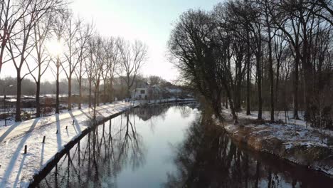 droneshot in of the river vecht in utrecht during sunrise in winter time with snow