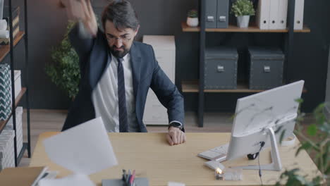 angry businessman throwing paper in office