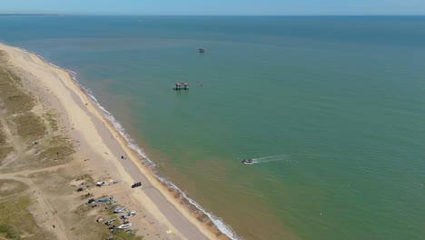 aerial drone view of fishing boat landing on english beach with fresh catch, north sea coast, sunny summer day