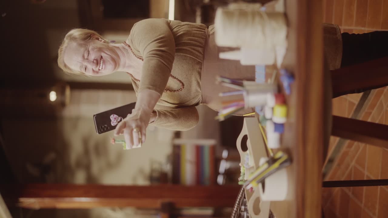 Smiling woman holding a smartphone while engaged in crafting