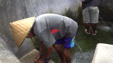 hombre lavando ropa tradicionalmente en un pueblo indonesio