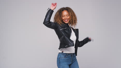 Wide-Angle-Studio-Shot-Of-Young-Woman-Wearing-Leather-Jacket-Dancing-In-Slow-Motion