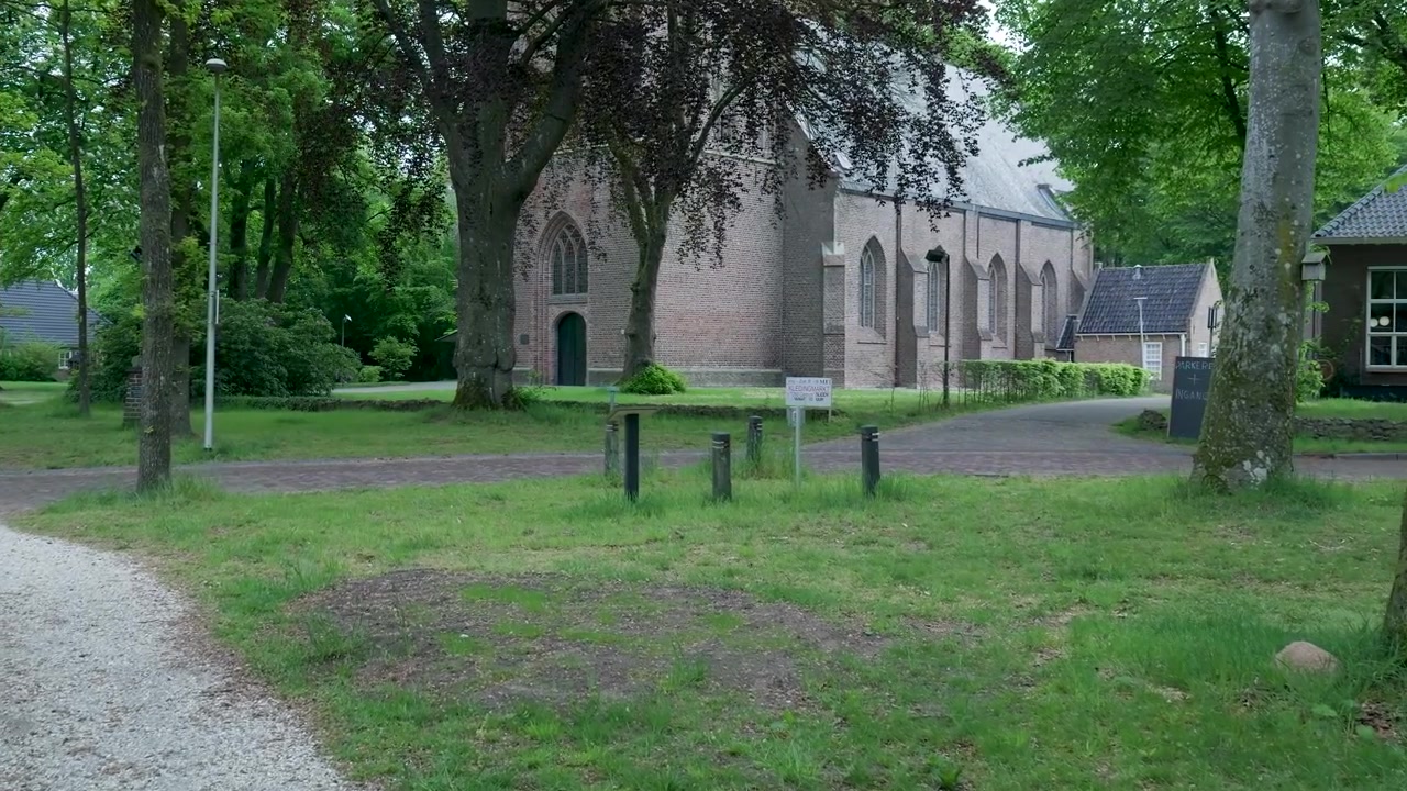 Historische Backsteinkirche, umgeben von üppig grünen Bäumen und Parkanlagen