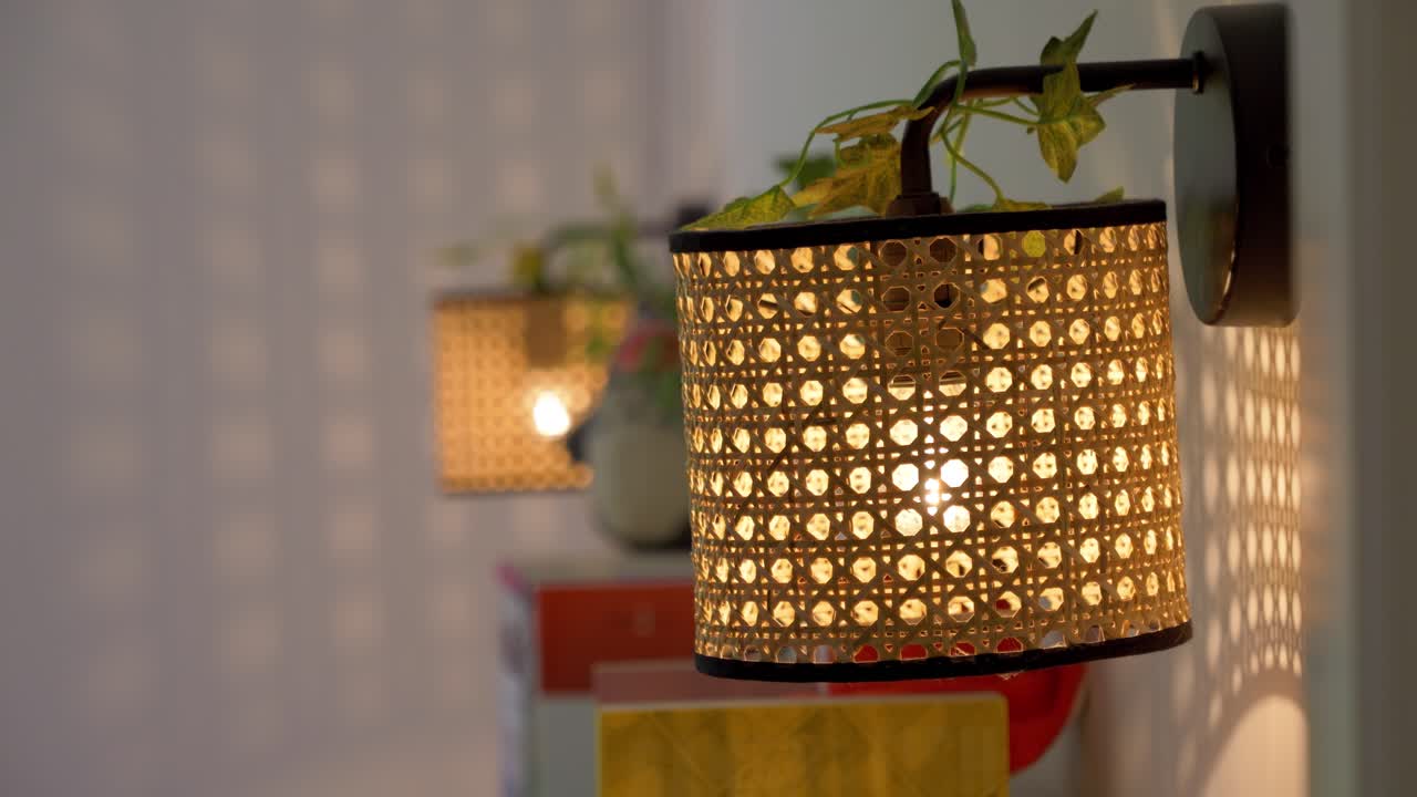 Slow revealing shot of patterned wicker lampshades hanging in a bedroom