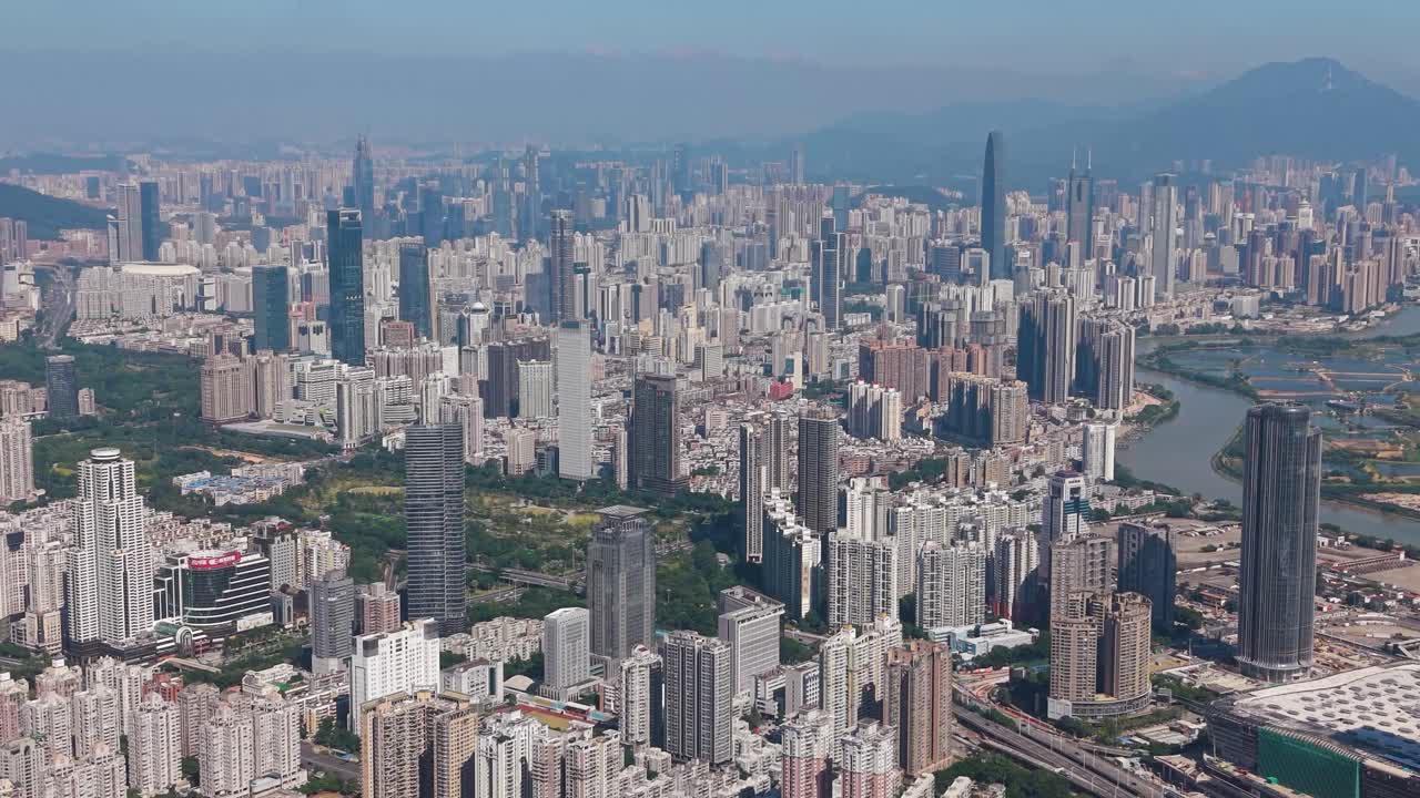 Close drone shot of Shenzhen city skyline in China, showcasing modern skyscrapers and the natural landscape along the Hong Kong border