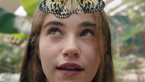 beautiful girl smiling with butterfly on face fluttering wings having fun with wildlife in nature conservation zoo 4k