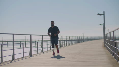 strong male athlete with prosthetic leg jogging on bridge.