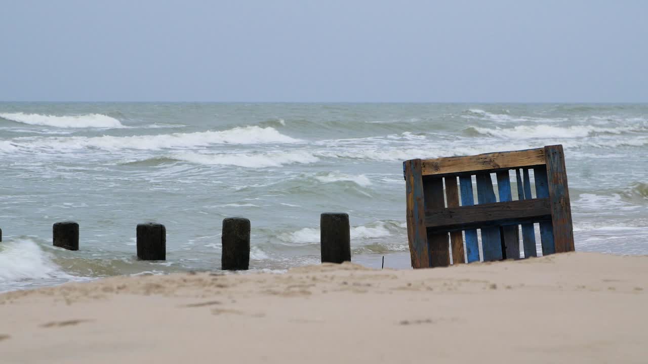 해변에 있는 오래된 푸른 나무 에팔 팔레트, 빈 발트해 백사장에 있는 쓰레기와 쓰레기, 환경 오염 문제, 흐린 날, 먼 중간 샷