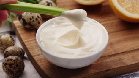 dipping celery in mayonnaise with quail eggs and orange