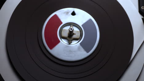 audio tape spinning on reel to reel recorder player, close up