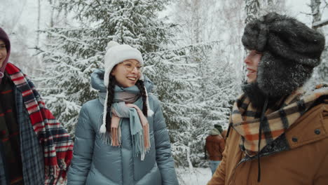 cheerful girlfriends chatting in winter forest