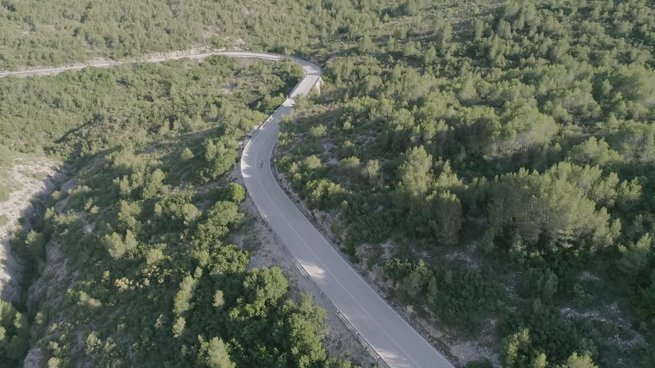 Aerial shot of roller skater riding a downhill mountain road