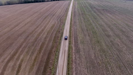 car drivin in middle of the empty field, aerial shot