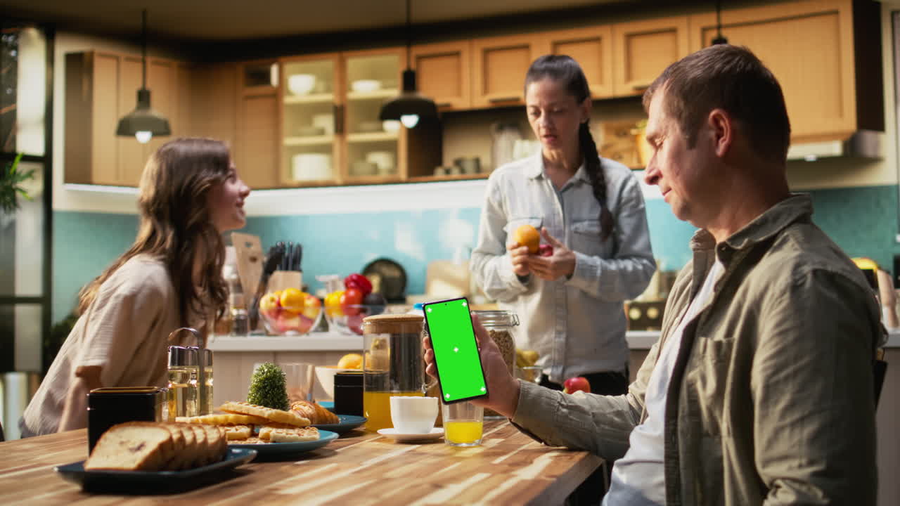 Vertical green screen on smartphone with family serving breakfast
