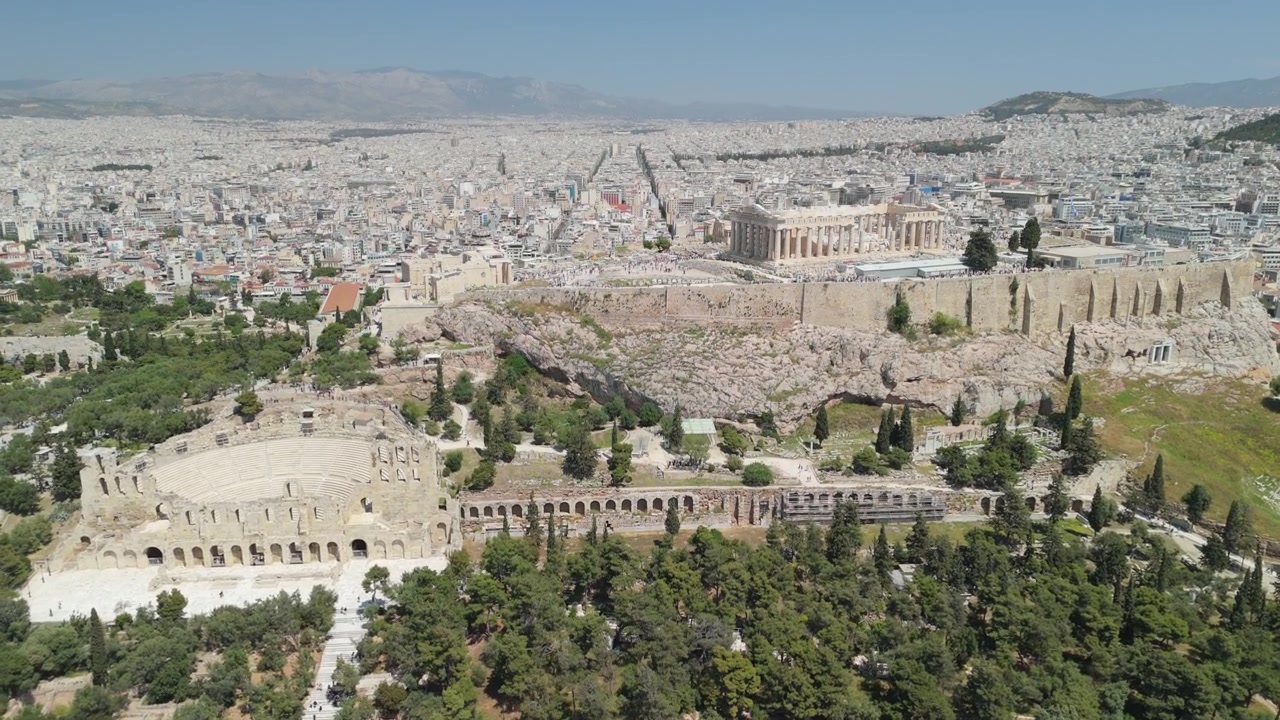 Vista aerea ascendente da drone dell'Acropoli, che rivela la città di Atene dietro lo storico monumento greco