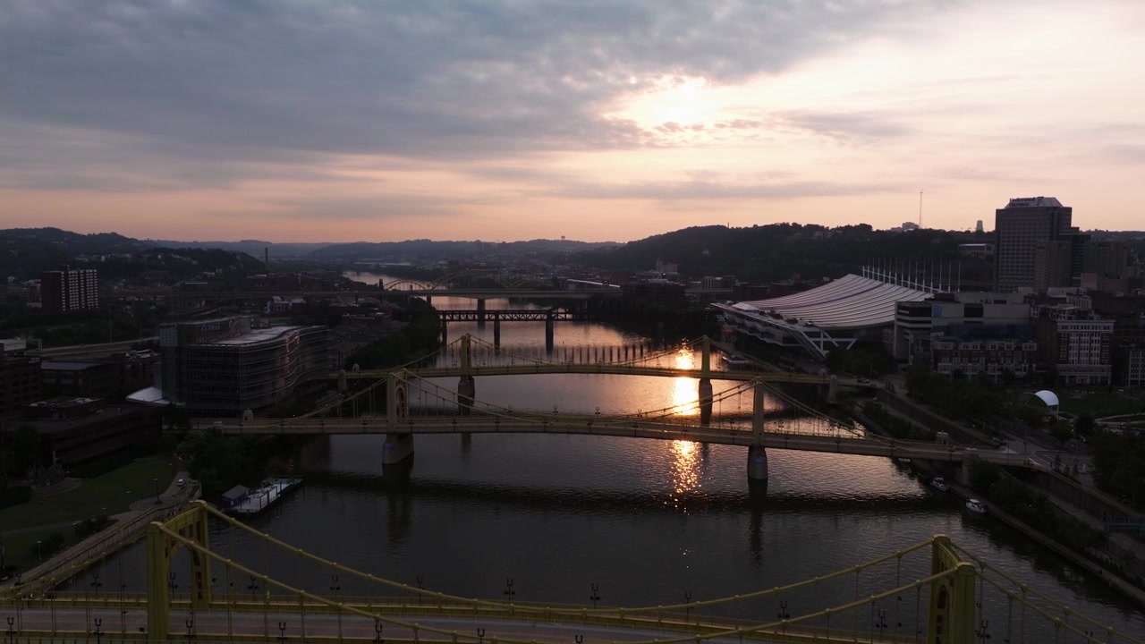 Ponti delle Tre Sorelle e lungofiume di Pittsburgh vicino al centro congressi al tramonto, panoramica aerea in ascesa.