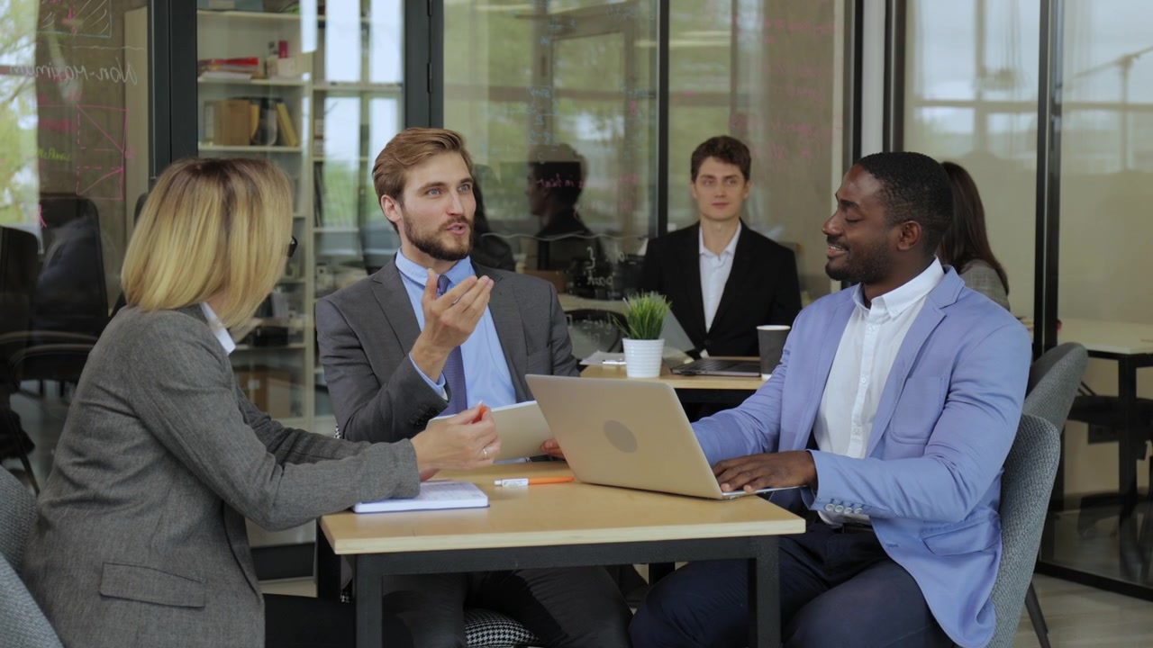 Equipe de Negócios Diversificada Discutindo Projeto em Escritório Moderno.