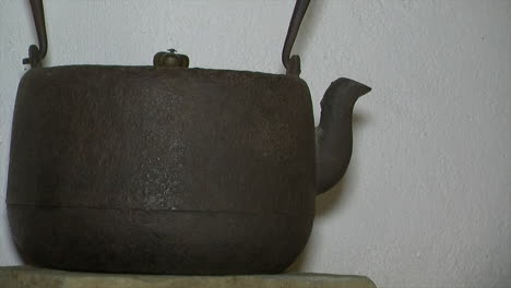 cast iron kettle rests on farmhouse kitchen shelf